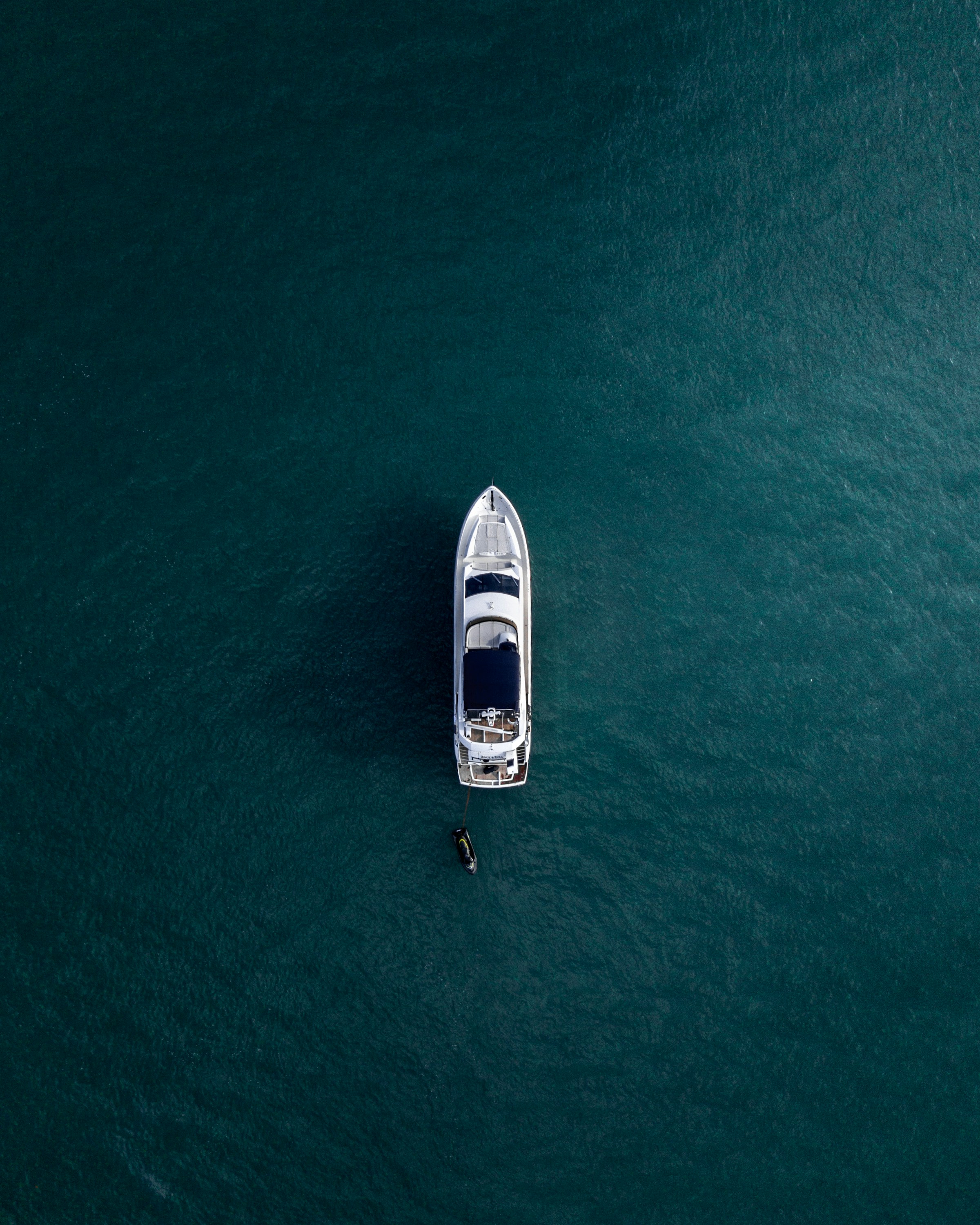 A white yacht seen from above on deep blue water